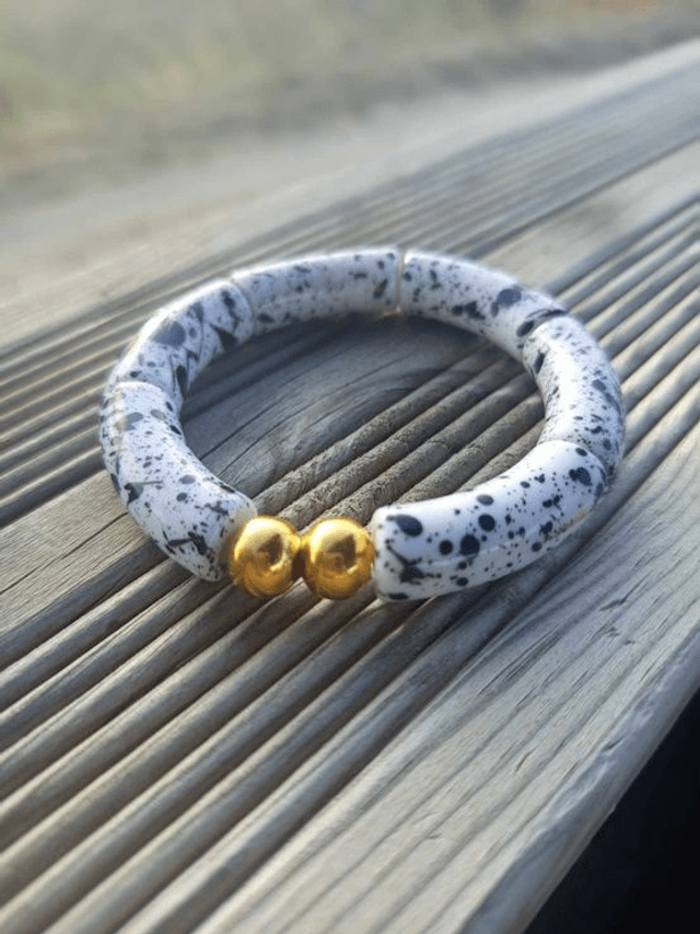 Bracelet perles tubes incurvées acryliques tâchetées Khazaana blanc et noir