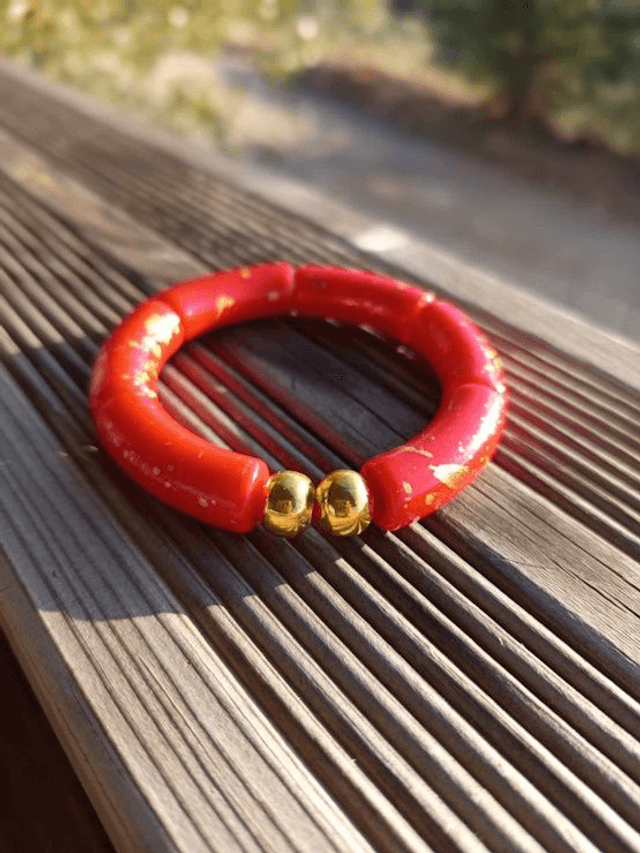 Bracelet perles tubes incurvées acryliques tâchetées Khazaana rouge