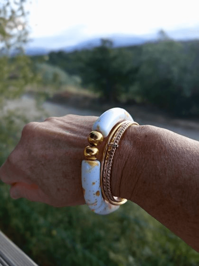 Bracelet perles tubes incurvées acryliques tâchetées Khazaana blanc et doré