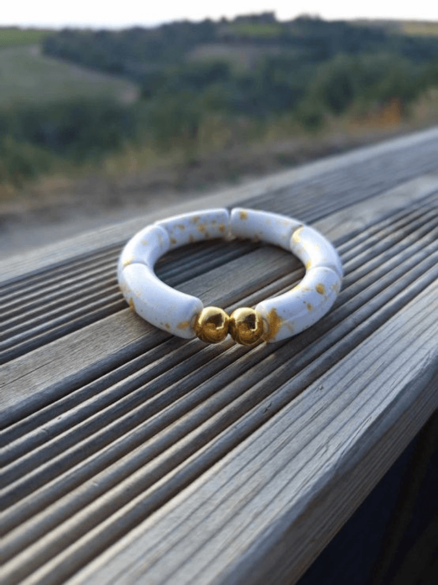 Bracelet perles tubes incurvées acryliques tâchetées Khazaana blanc et doré